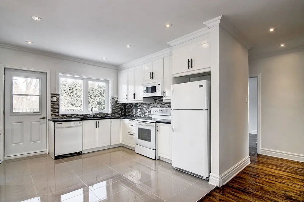 Modern kitchen renovation in Montreal with white cabinets and quartz countertops